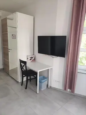 a white desk with a television on a wall at Apoteka in Lenart v Slovenskih Goricah