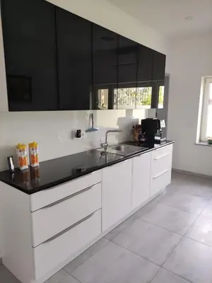 a white kitchen with black cabinets and a sink at Apoteka in Lenart v Slovenskih Goricah