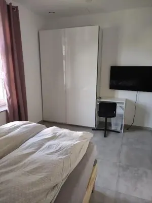 a bedroom with a bed and a flat screen tv at Apoteka in Lenart v Slovenskih Goricah