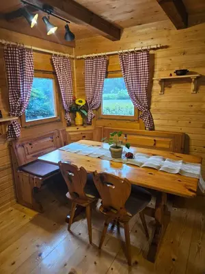 a dining room with a wooden table in a cabin at Cottage Ladybug in Mojstrana