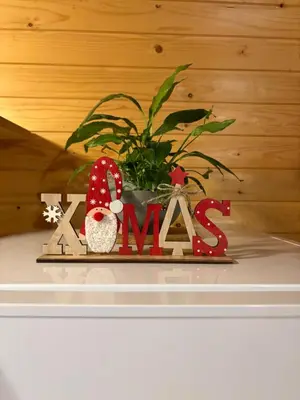 a christmas sign on a table with a plant at Cottage Ladybug in Mojstrana