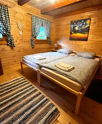 a bedroom with a bed in a log cabin at Cottage Ladybug in Mojstrana