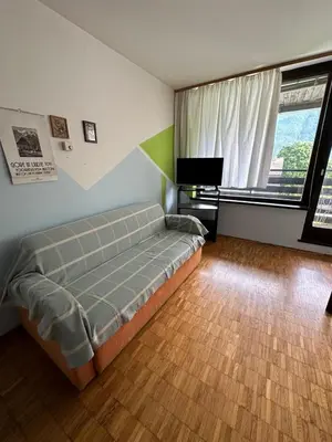 a bedroom with a bed and a large window at Apartma Marjeta in Bovec