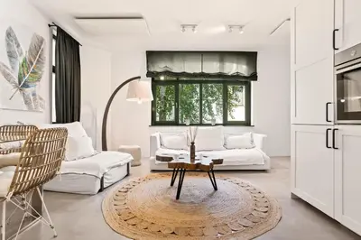a living room with white furniture and a table at Apartments Mazijeva in Ljubljana