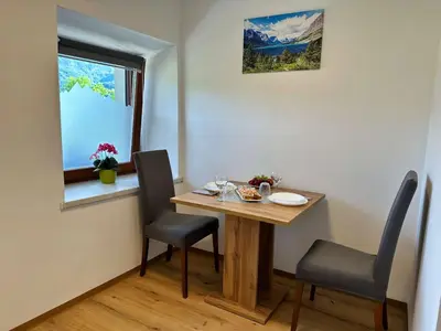 a small table and chairs in a room with a window at Bijol Apartments in Bled