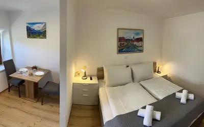 a small bedroom with a bed and a table at Bijol Apartments in Bled