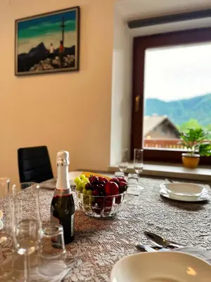 a table with a bottle of wine and a bowl of fruit at Bijol Apartments in Bled