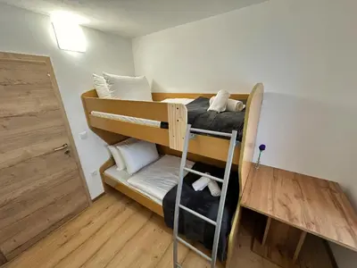 a room with two bunk beds and a desk at Bijol Apartments in Bled