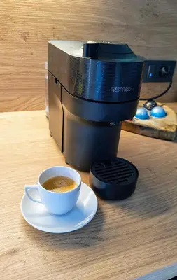 a coffee maker with a cup of coffee on a table at Relax apartment Ljubljana in Ljubljana