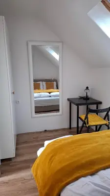 a bedroom with a mirror and a bed and a table at Apartma Harmonia with parking in Bled