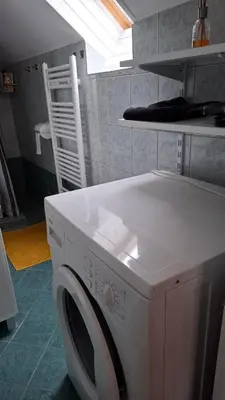 a white washing machine in a kitchen with a window at Apartma Harmonia with parking in Bled