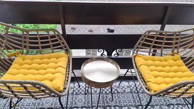 two chairs with yellow cushions sitting on a balcony at Apartma Harmonia with parking in Bled