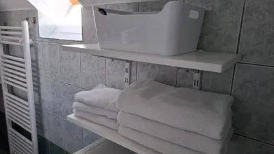 a pile of towels on a shelf in a bathroom at Apartma Harmonia with parking in Bled