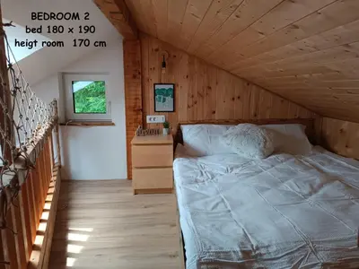 a bed in a room with a wooden ceiling at RELAX HOUSE Kolpa view Podzemelj in Gradac