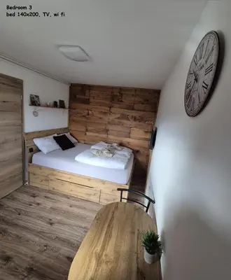 a bedroom with a bed and a clock on the wall at RELAX HOUSE Kolpa view Podzemelj in Gradac