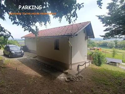 a small house with a car parked in front of it at RELAX HOUSE Kolpa view Podzemelj in Gradac