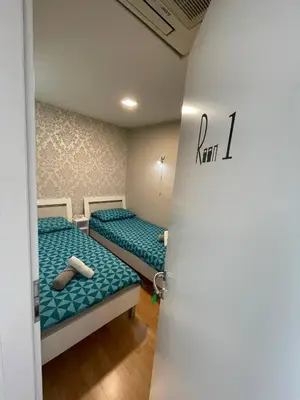 a room with two beds and a door with the word rent at Granada Rooms in Ljubljana