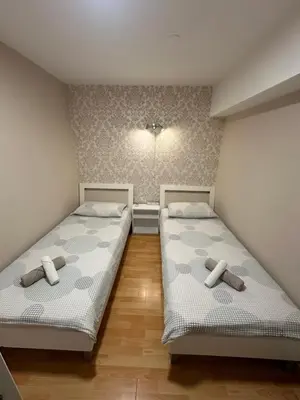two twin beds in a room with wooden floors at Granada Rooms in Ljubljana