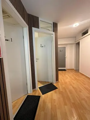 an empty room with white doors and a wooden floor at Granada Rooms in Ljubljana