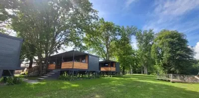a house on a grassy field with trees at BIG BERRY KOLPA - KIWI mobile house, Metlika in Gradac