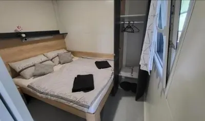 a small bed with two black pillows on it at BIG BERRY KOLPA - KIWI mobile house, Metlika in Gradac