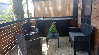 a patio with chairs and a table with a plant on it at BIG BERRY KOLPA - KIWI mobile house, Metlika in Gradac