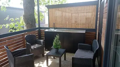a patio with chairs and a table and a fountain at BIG BERRY KOLPA - KIWI mobile house, Metlika in Gradac