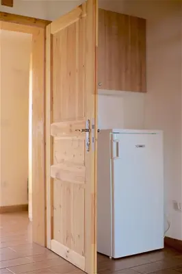a door leading into a kitchen with a refrigerator at Tourist Farm Apartments Lovrec in Jiršovci