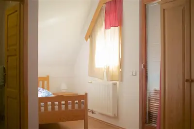 a small room with a crib and a window at Tourist Farm Rooms Lovrec in Jiršovci