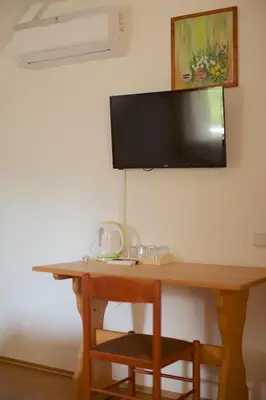a wooden desk with a television on a wall at Tourist Farm Rooms Lovrec in Jiršovci