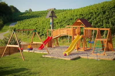 a park with a playground with slides and swings at Tourist Farm Rooms Lovrec in Jiršovci