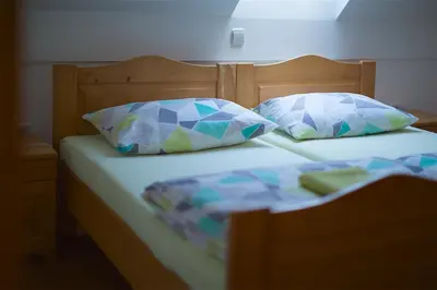 a bed with two pillows on it with at Tourist Farm Rooms Lovrec in Jiršovci
