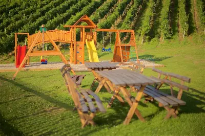 a playground with a table and benches in a field at Tourist Farm Rooms Lovrec in Jiršovci