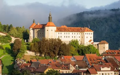 a large castle on top of a town with houses at Starling Loka in Škofja Loka