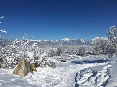 a snow covered road with a yellow fire hydrant at Starling Loka in Škofja Loka
