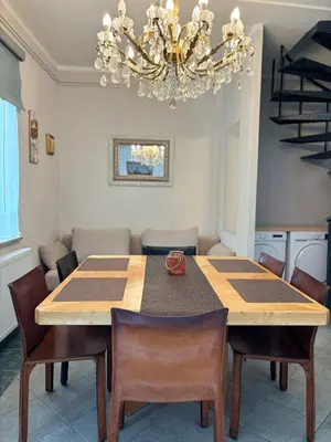 a dining room with a table and chairs and a chandelier at Avrora House FREE parking in OLD TOWN in Ljubljana