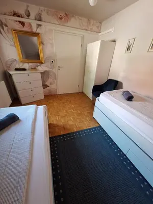 a bedroom with two beds and a dresser and a mirror at Avrora House FREE parking in OLD TOWN in Ljubljana
