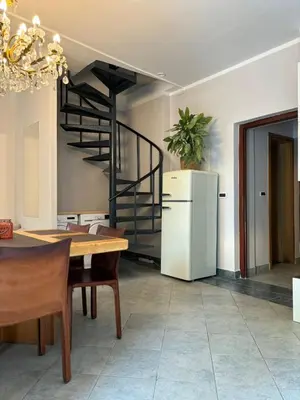 a dining room with a refrigerator and a staircase at Avrora House FREE parking in OLD TOWN in Ljubljana