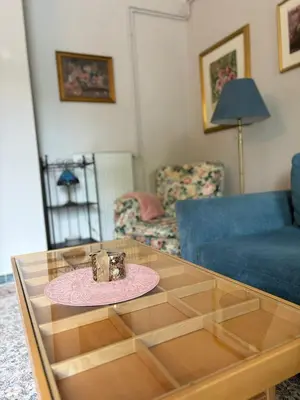 a living room with a table and a blue couch at Avrora House FREE parking in OLD TOWN in Ljubljana