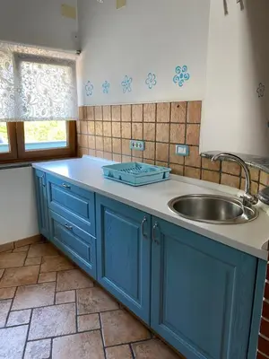 a kitchen with blue cabinets and a sink at Apartma CASA CELESTE in Renče