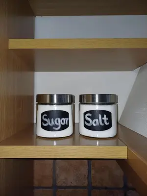 two containers of sugar and salt sitting on a shelf at Apartma CASA CELESTE in Renče