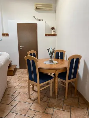 a dining room with a wooden table and chairs at Apartma CASA CELESTE in Renče