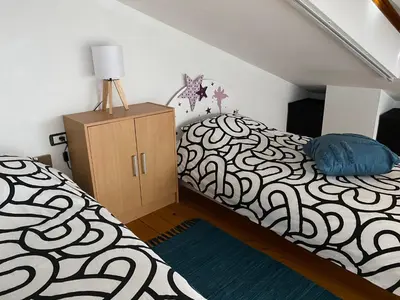 a bedroom with a black and white bed and a dresser at Apartma CASA CELESTE in Renče