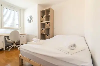 a white bedroom with a desk and a bed at The Elegant Retreat in Ljubljana