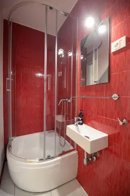 a red tiled bathroom with a sink and a shower at The Elegant Retreat in Ljubljana