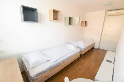 a room with two beds and a tv on the wall at The Elegant Retreat in Ljubljana