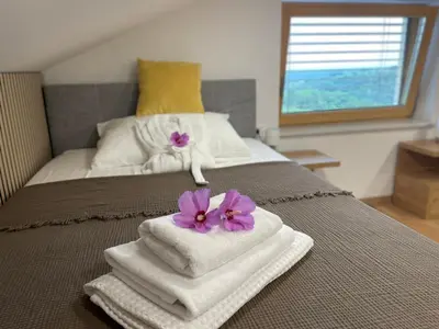 a bedroom with towels and flowers on a bed at Wellness Počitniška hiša Manja in Ljutomer