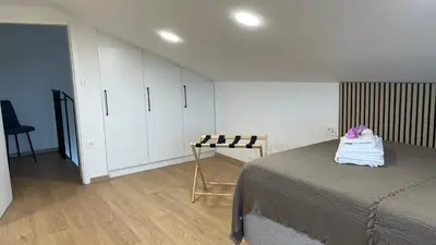 a bedroom with a bed and a table and cabinets at Wellness Počitniška hiša Manja in Ljutomer