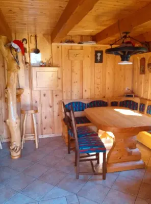 a dining room with a table and chairs in a cabin at Hiška vogar in Bohinj