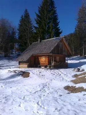 a log cabin with snow in front of it at Hiška vogar in Bohinj